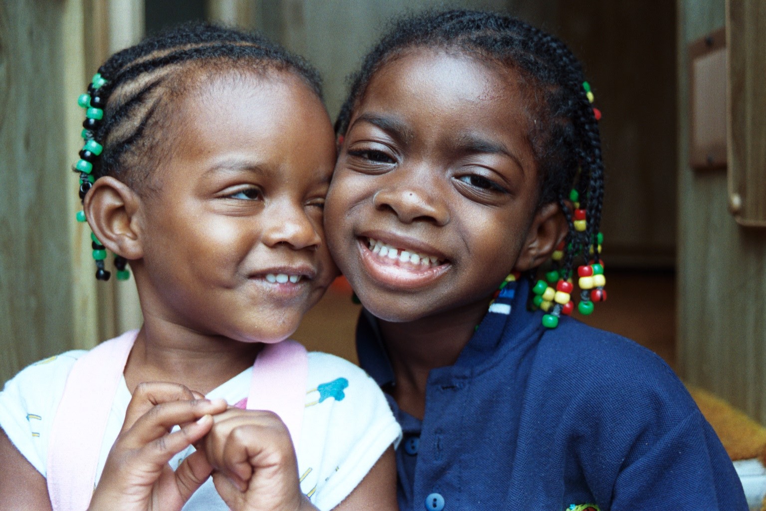 Beaded hair smiling sisters ready for the reggae festival.