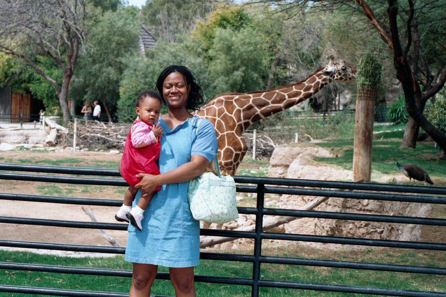 At Reid Park zoo Fortune and Mommy in fron of eating girafe.