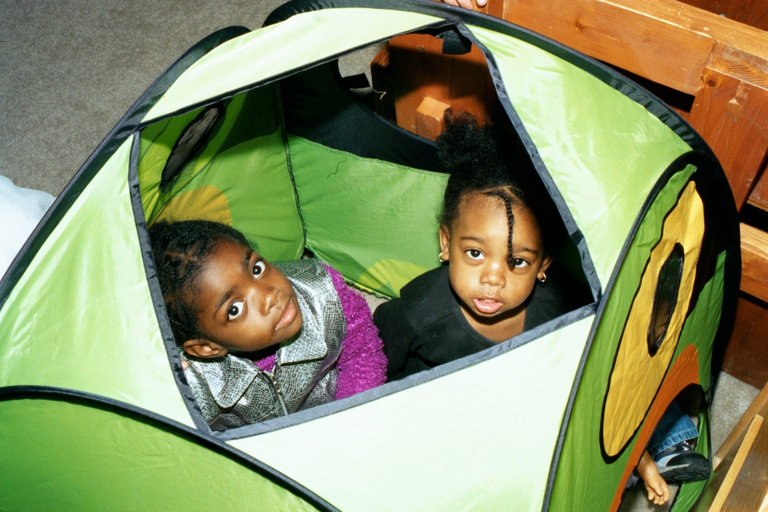 Blessin with her niece Nia peer out of their tent.